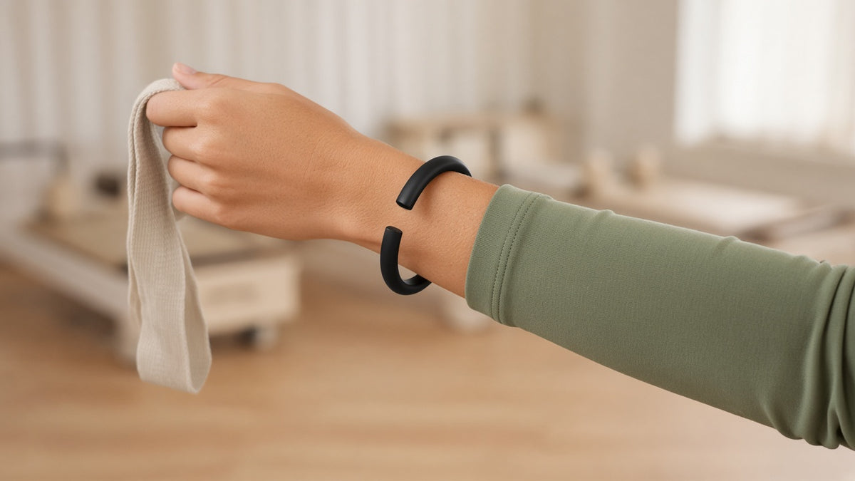 Black silicone bangle wrist weight being worn in a Pilates studio